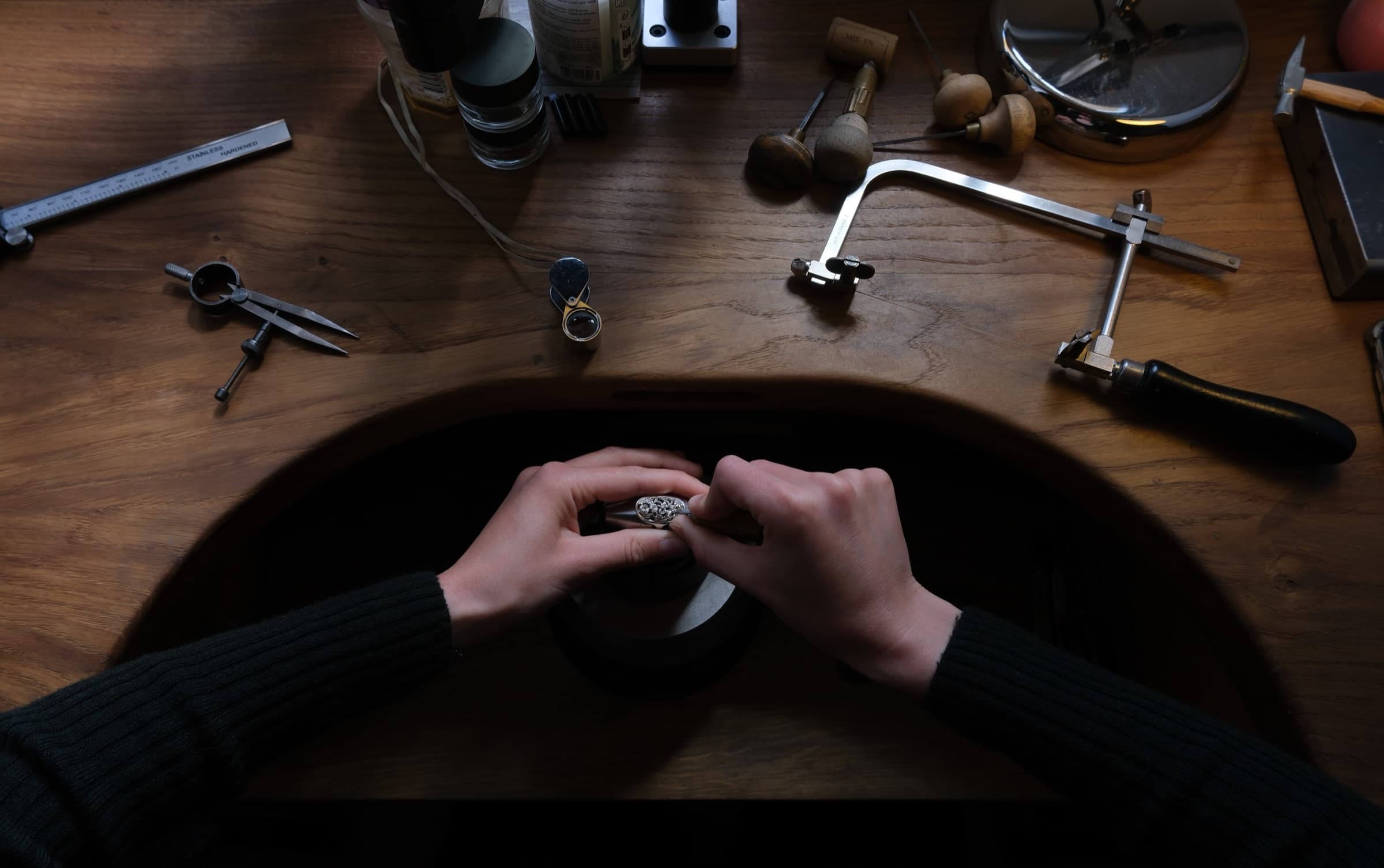 Mains gravant une médaille dans l'atelier de Maëva Martin